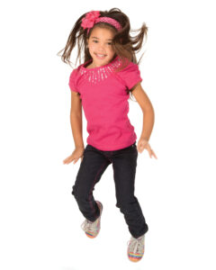 School-aged girl in a pink shirt jumping